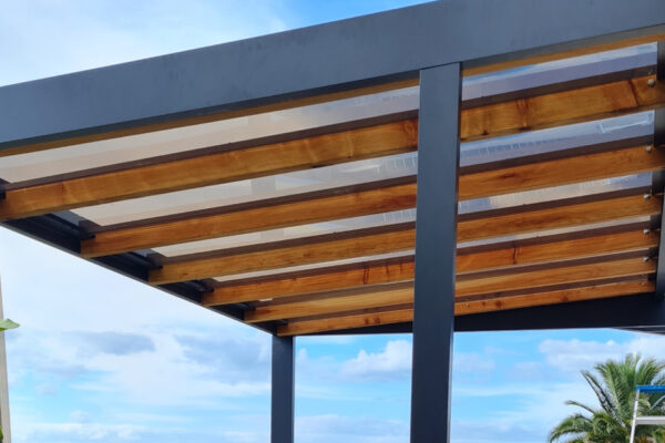 A mono-pitch glass pergola constructed of wood and metal framing.