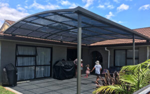 A curved pergola covering a large concrete patio area.