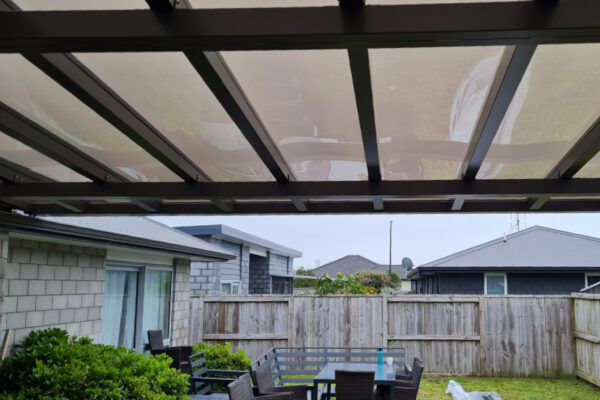 A pergola constructed of metal and opaque material to let sunlight through.