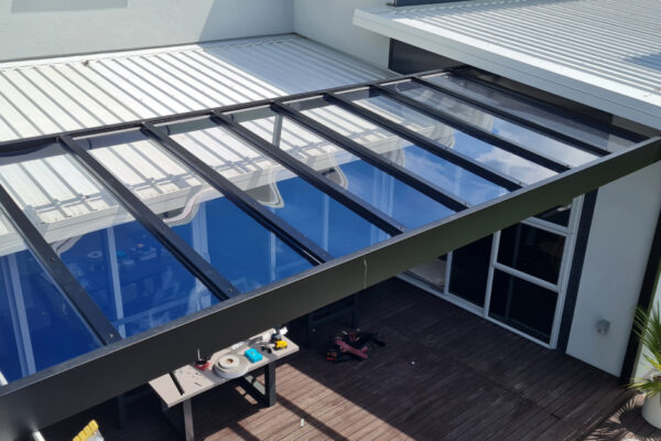 Glass is fabricated into a metal frame pergola to allow maximum sunlight to enter patio.