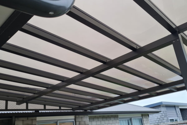 Mono-pitch pergola constructed of opaque material and metal framing.