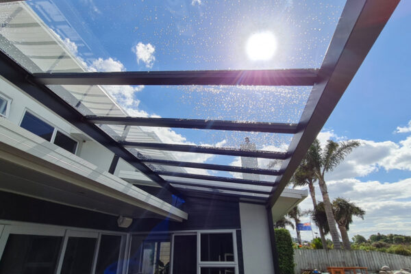 Looking up through a pergola designed of glass and metal framing.