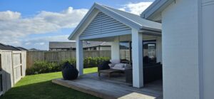 A pergola constructed with metal roofing and decorative louvre in front.