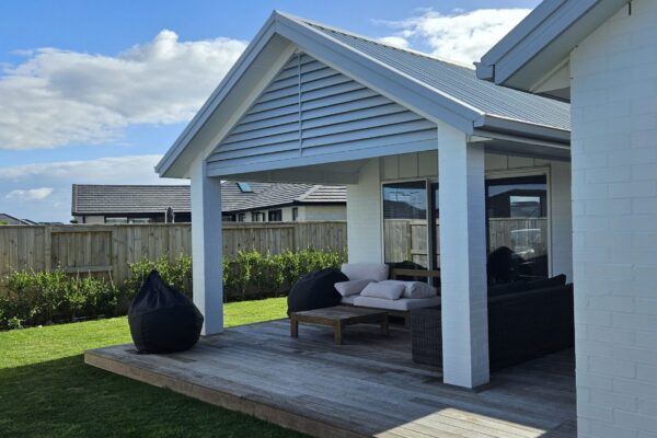 A pergola constructed with metal roofing and decorative louvre in front.