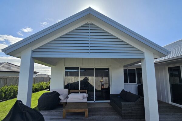 Pergola covering a porch with decorative louvre installed in peak.