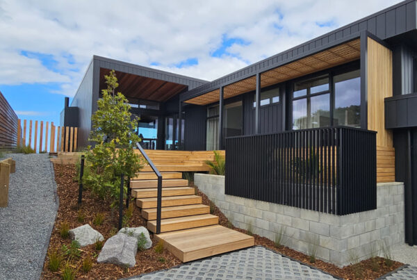 Steps lead up to a mono-pitch pergola on a contemporary house.