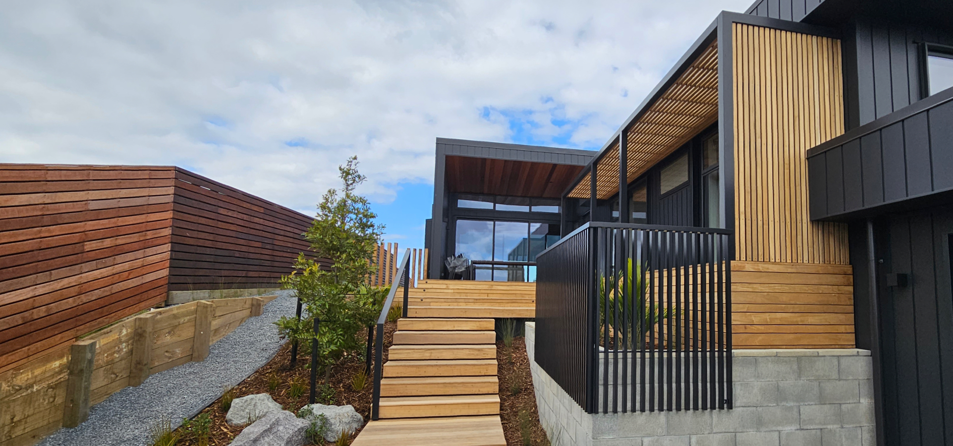 Stairs leading up to a pergola at a home's entrance.