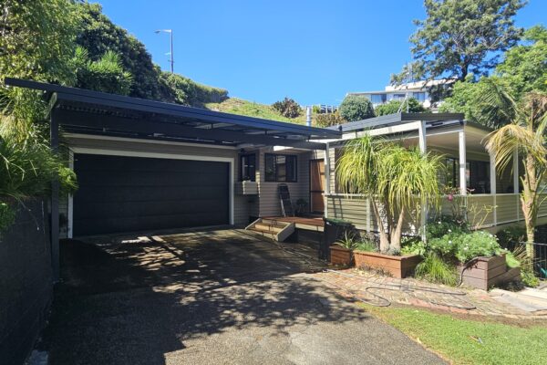 Pergola extended over garage opening to provide shelter from the elements.