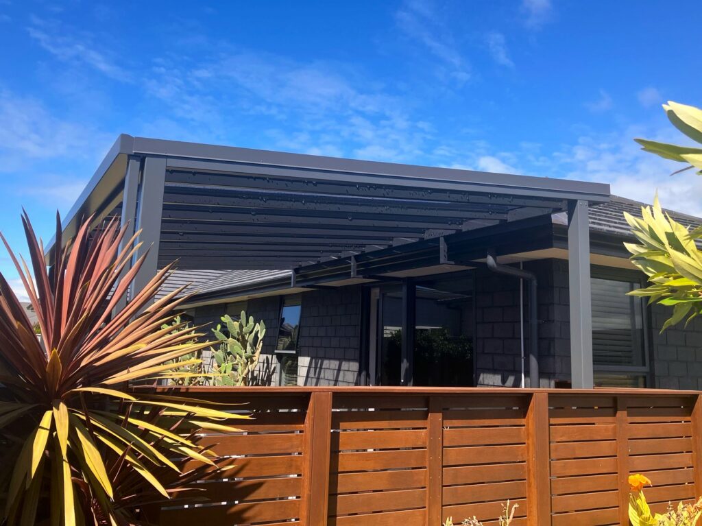 A mono-pitch pergola covers an outdoor dining space.