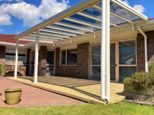A mono-pitch pergola with skylight-style roofing over a deck.