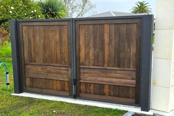 An aluminium frame gate with timber insert leads into a side yard.