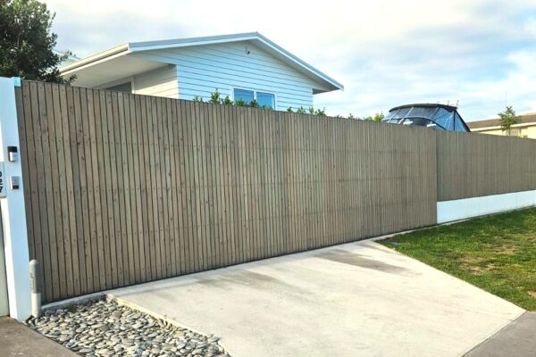 A solid panel automated sliding gate is installed in a driveway for enhanced home security.